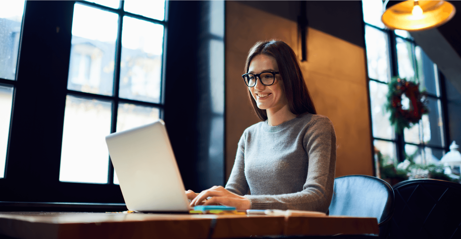 Women wearing glasses and smiling on laptop